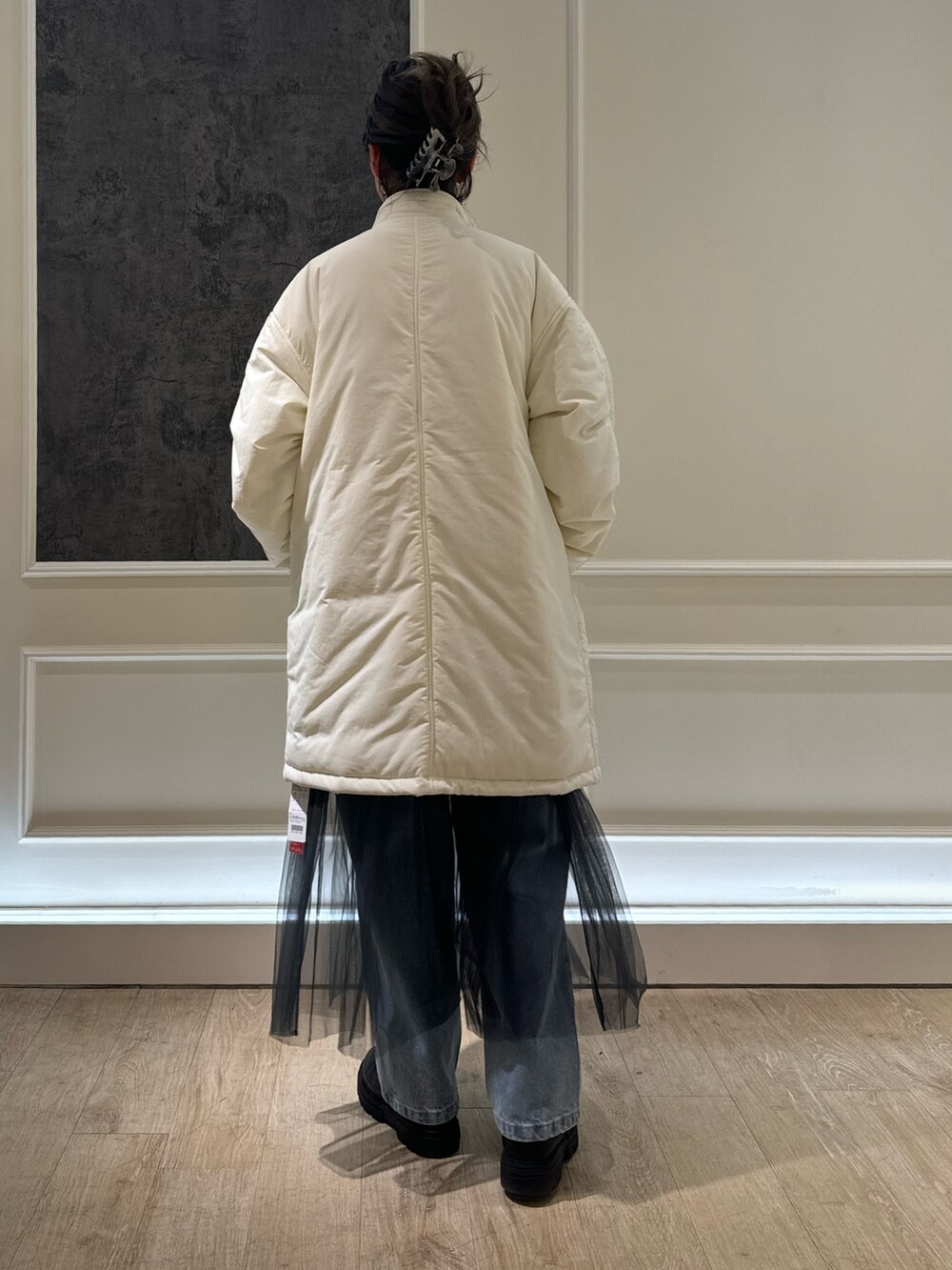 グリーン系のモッズコート、グレー系のTシャツ/カットソー、グレー系のスカートを着用したレディースの冬コーディネートの2枚目の写真