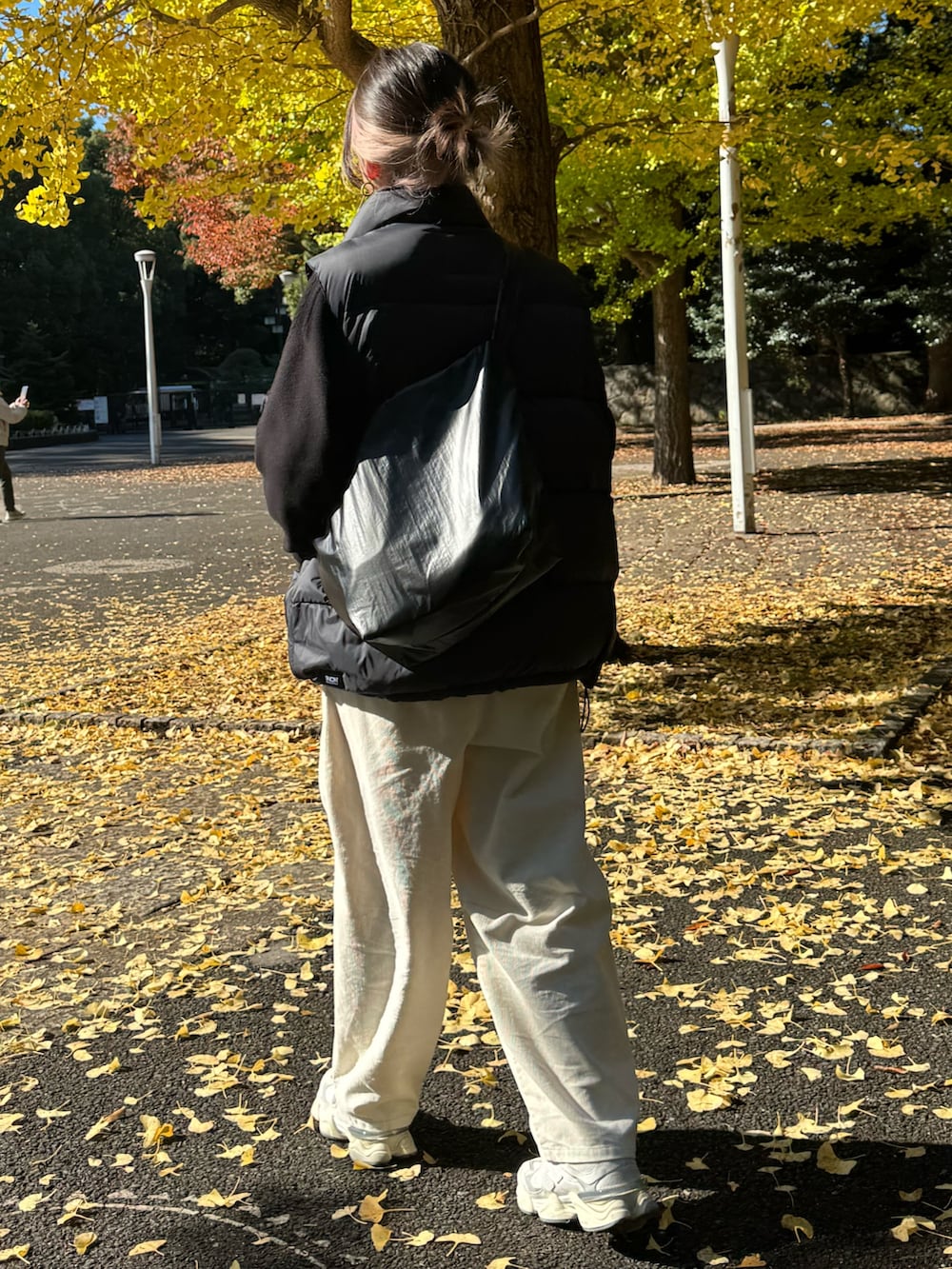 ブラック系のダウンベスト、ブラック系のニット/セーター、ホワイト系のその他パンツを着用したレディースの冬コーディネートの7枚目の写真