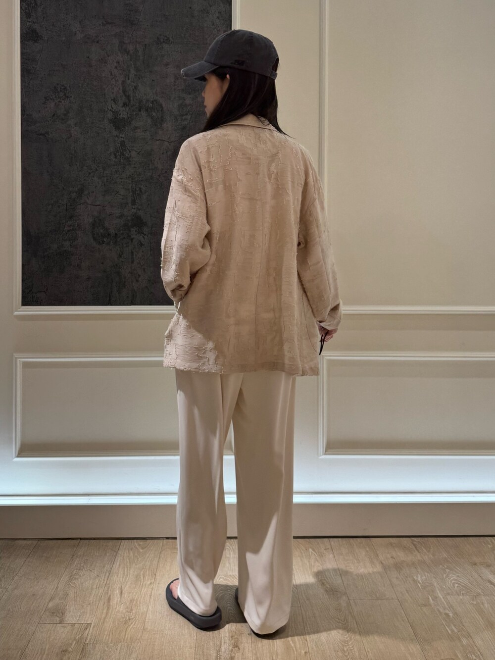 ベージュ系のテーラードジャケット、ブラック系のサンダル、ホワイト系のその他パンツを着用したレディースの春コーディネートの5枚目の写真