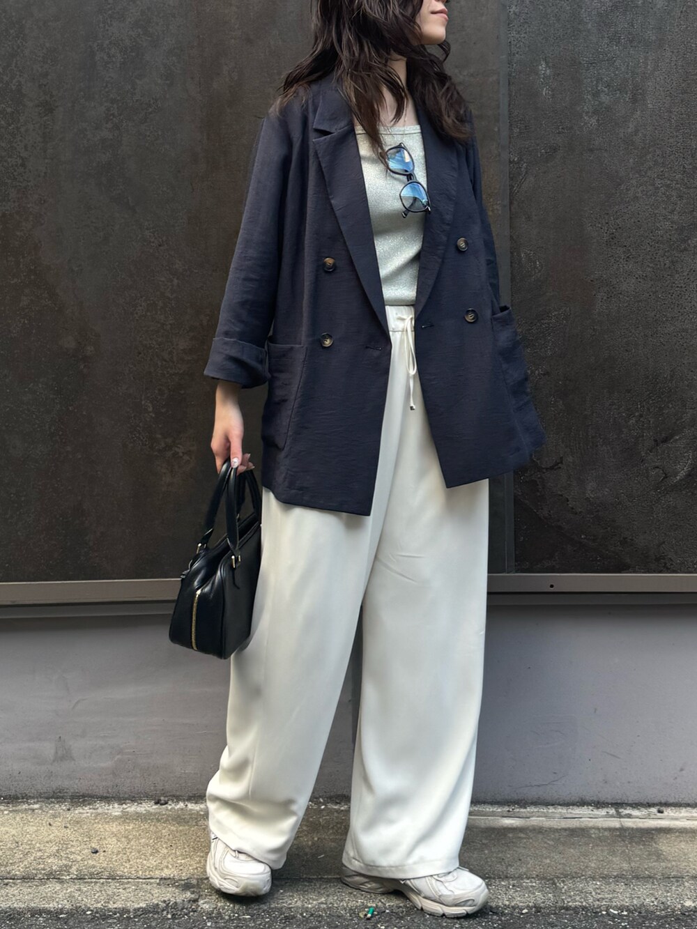 イエロー系のショルダーバッグ、ベージュ系のテーラードジャケット、ベージュ系のその他パンツを着用したレディースの春コーディネートの5枚目の写真