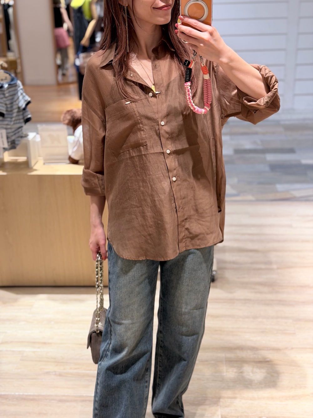 ブラウン系のシャツ/ブラウス、ブルー系のデニムパンツ、ベージュ系のショルダーバッグを着用したレディースの夏コーディネートの4枚目の写真