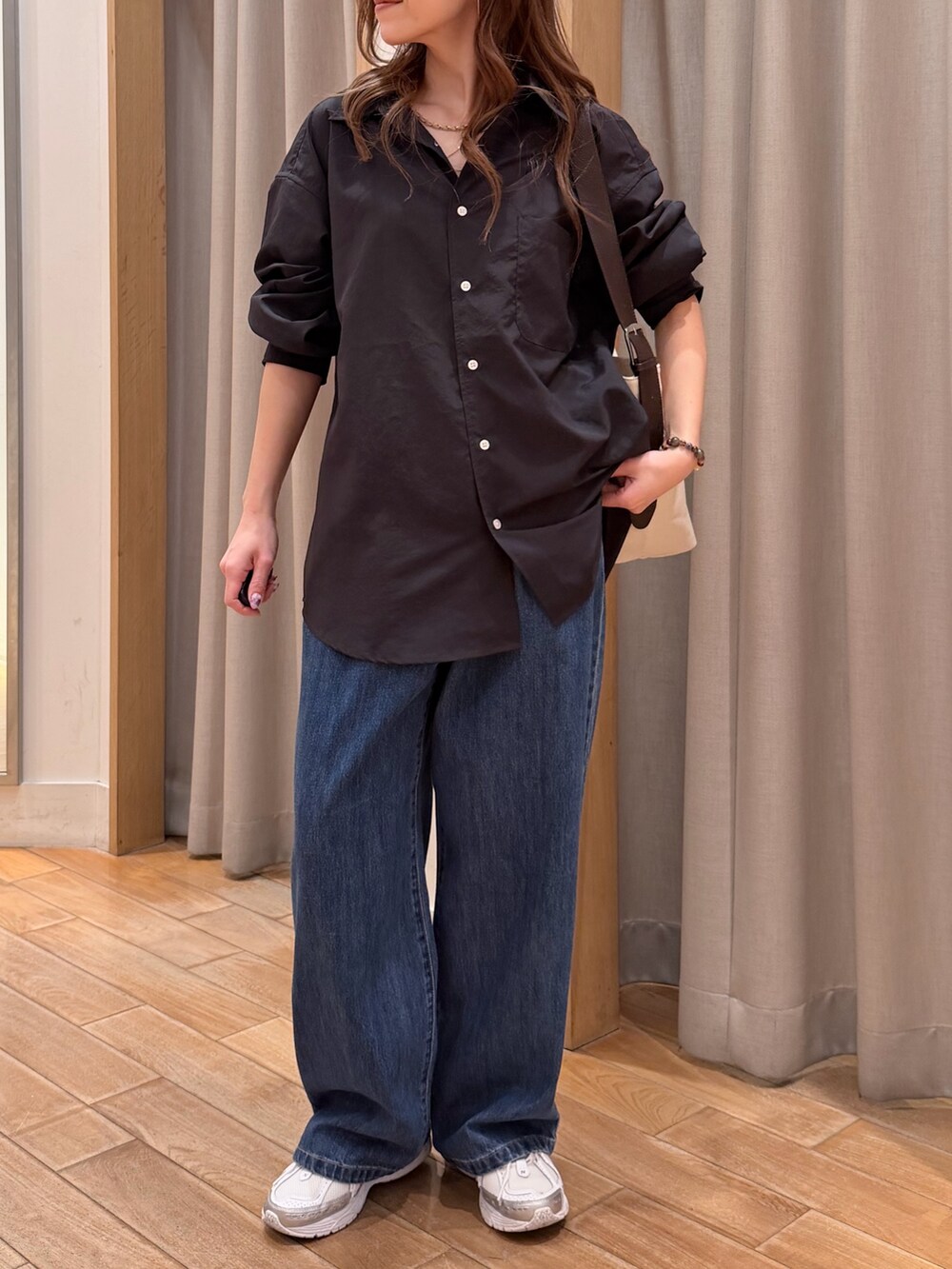 グレー系のシャツ/ブラウス、ブルー系のデニムパンツ、ブラック系のショルダーバッグを着用したレディースの春コーディネートの2枚目の写真