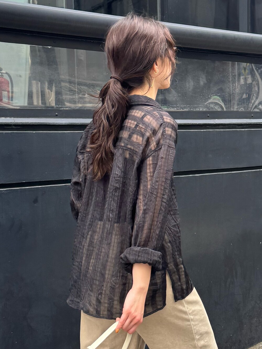 ブラック系のシャツ/ブラウス、ベージュ系のデニムパンツを着用したレディースの春コーディネートの5枚目の写真