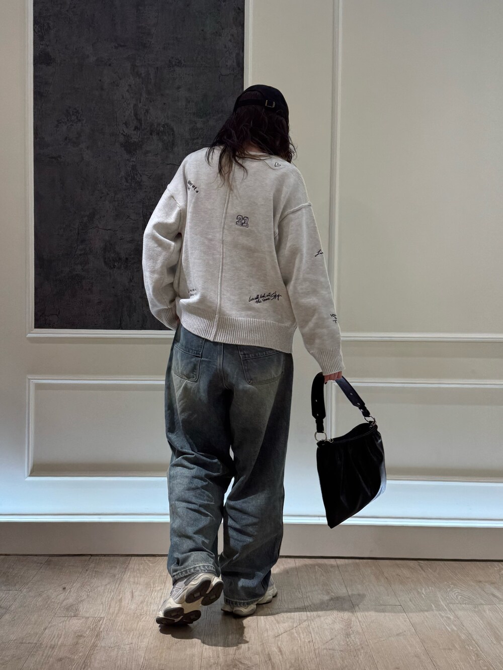 ホワイト系のカーディガン/ボレロ、ブルー系のデニムパンツ、ブラック系のショルダーバッグを着用したレディースの冬コーディネートの5枚目の写真