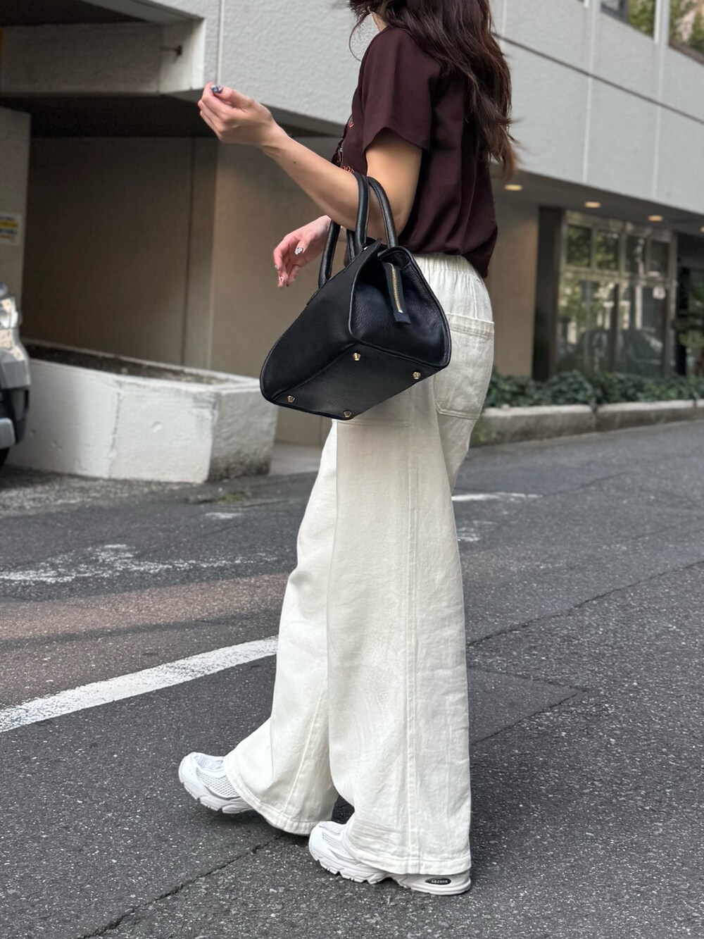 ブラウン系のTシャツ/カットソー、ホワイト系のデニムパンツ、ブラック系のショルダーバッグを着用したレディースの夏コーディネートの4枚目の写真