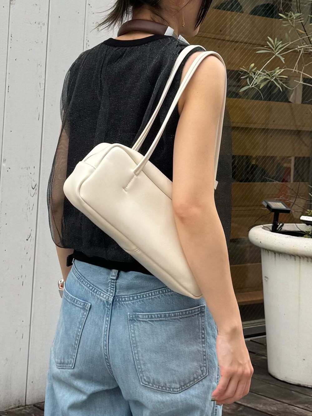 ブラック系のタンクトップ、シルバー系のサンダル、ホワイト系のボストンバッグを着用したレディースの夏コーディネートの2枚目の写真