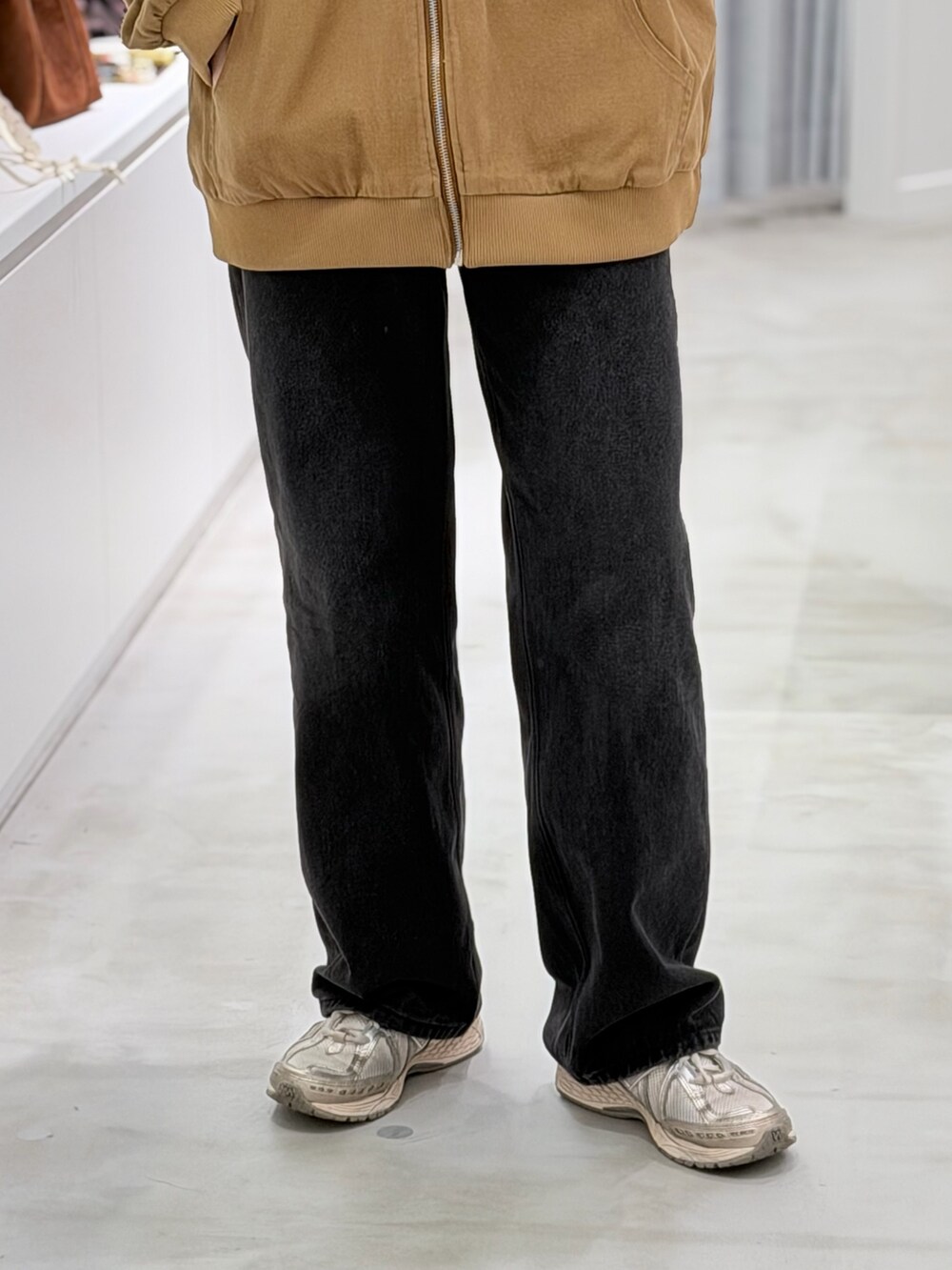 ベージュ系のブルゾン、ブラック系のデニムパンツを着用したレディースの春コーディネートの3枚目の写真