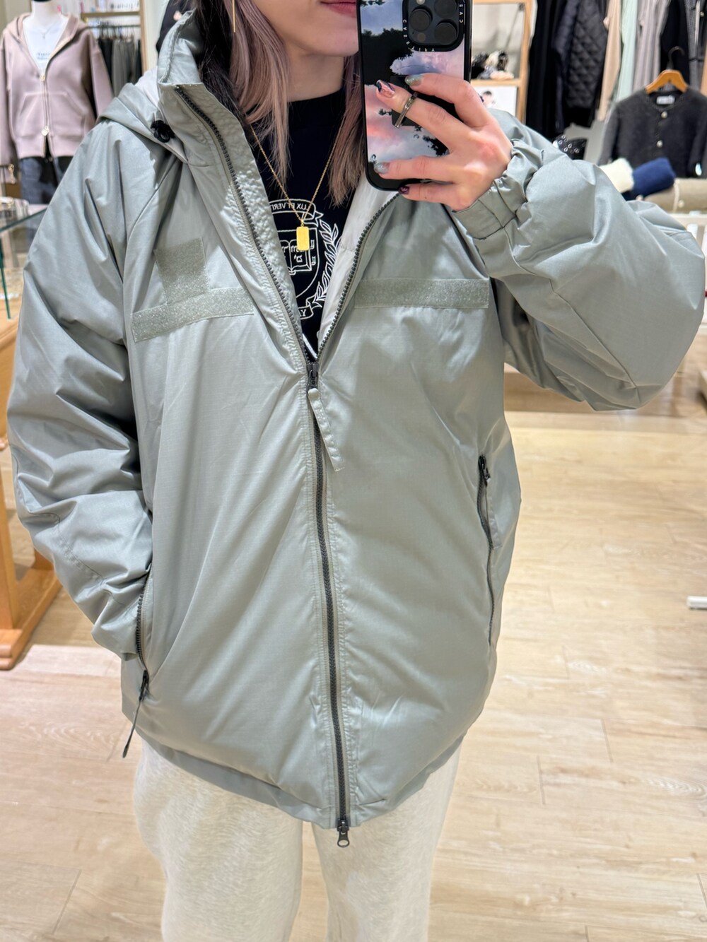 グリーン系のダウンジャケット/コート、ベージュ系のスウェットパンツ、ブルー系のキャップを着用したレディースの秋コーディネートの2枚目の写真