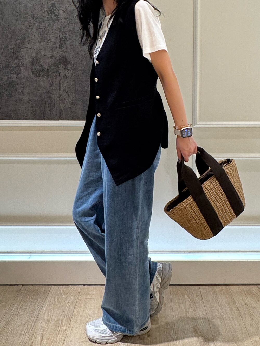 ブルー系のデニムパンツ、ブラック系のベスト、ホワイト系のTシャツ/カットソーを着用したレディースの夏コーディネートの4枚目の写真