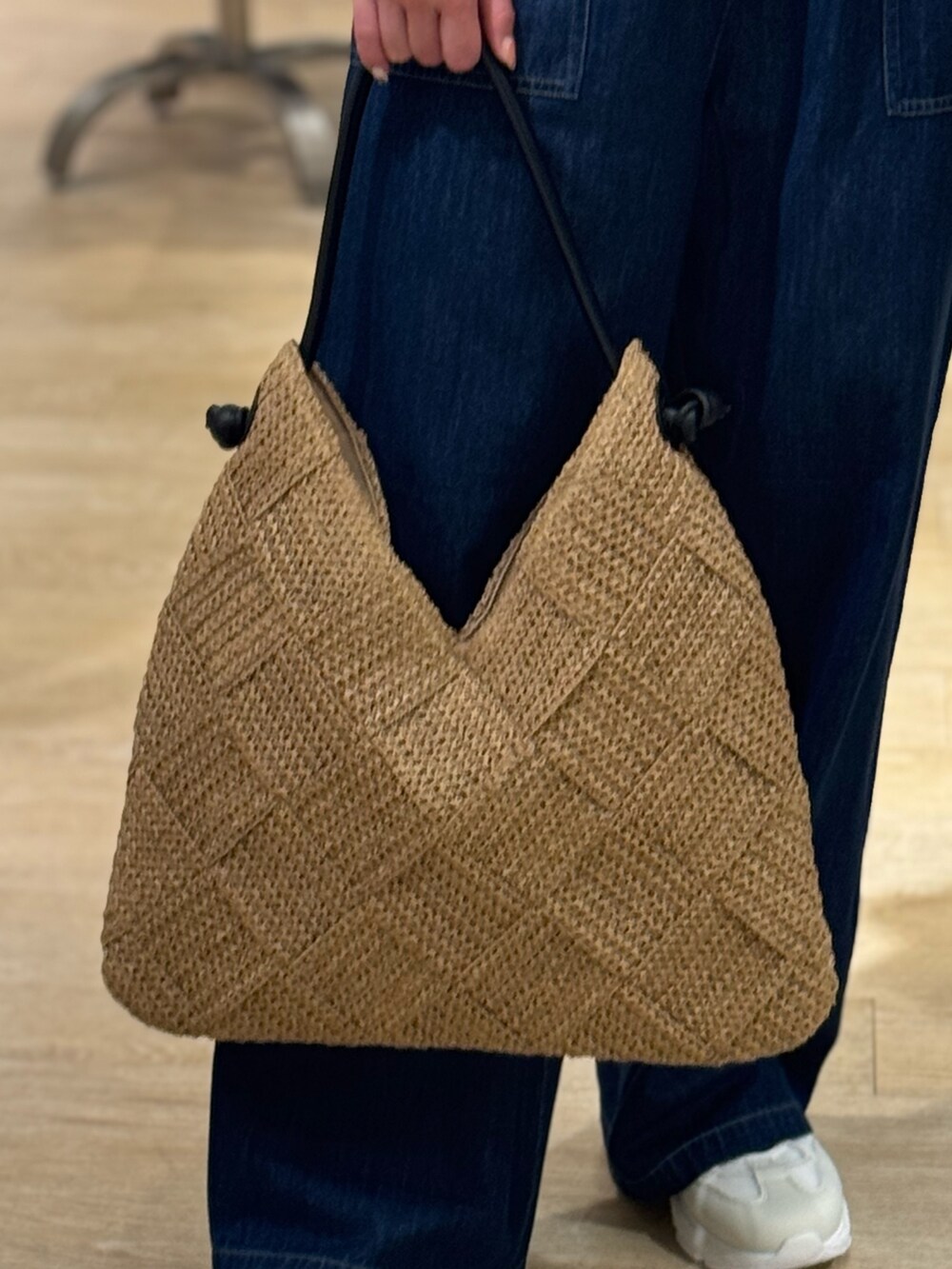 グレー系のTシャツ/カットソー、ブルー系のデニムパンツ、ベージュ系のかごバッグを着用したレディースの夏コーディネートの4枚目の写真