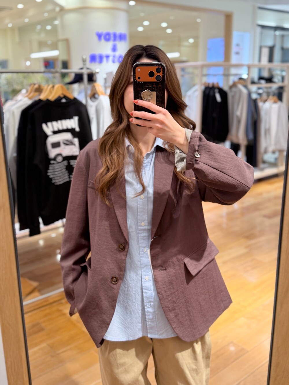 ブラウン系のテーラードジャケット、ベージュ系のチノパンツ、ブルー系のシャツ/ブラウスを着用したレディースの春コーディネートの2枚目の写真