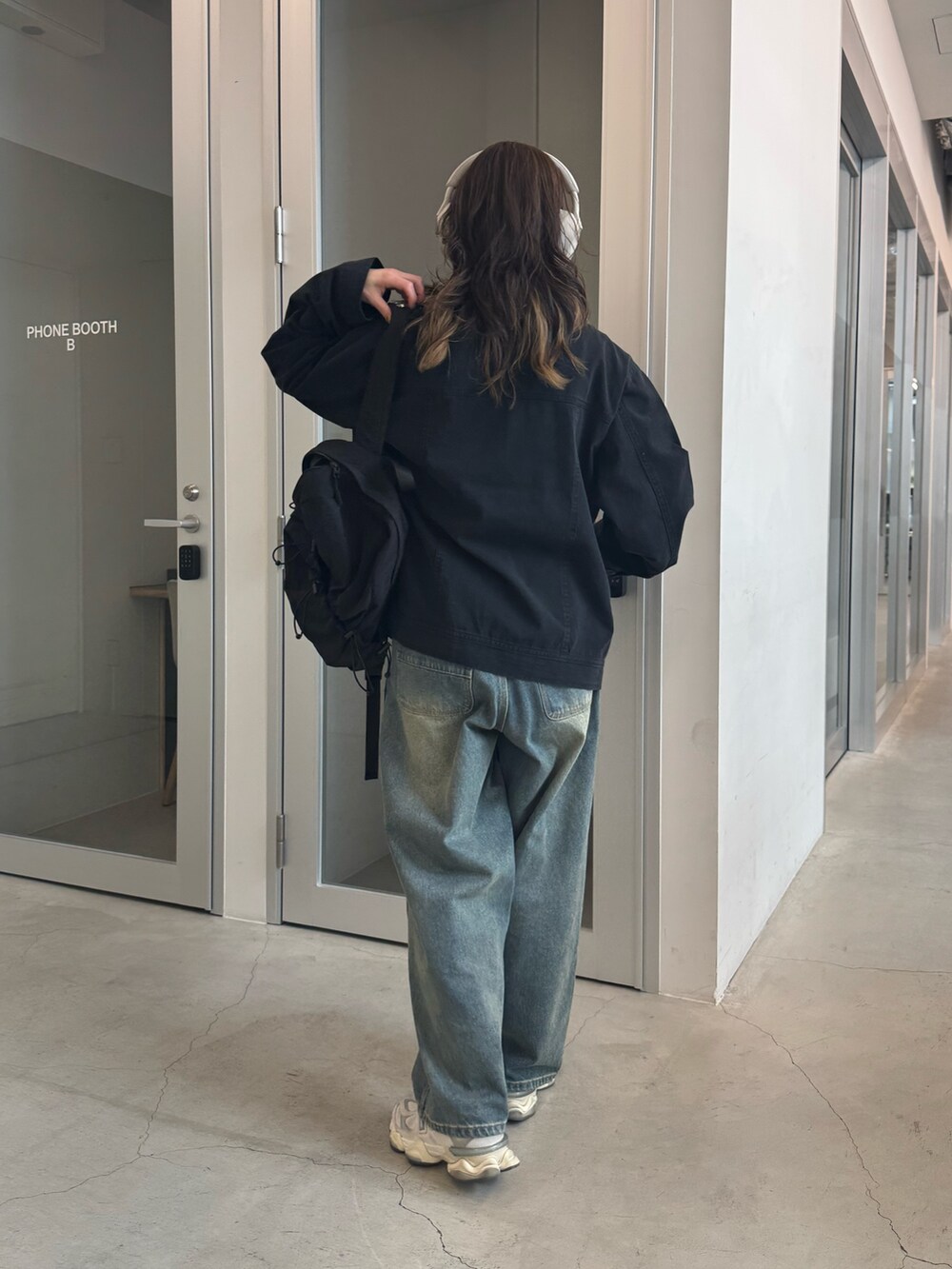 ブラック系のブルゾン、ブルー系のデニムパンツ、ブラック系のバックパック/リュックを着用したレディースの冬コーディネートの3枚目の写真