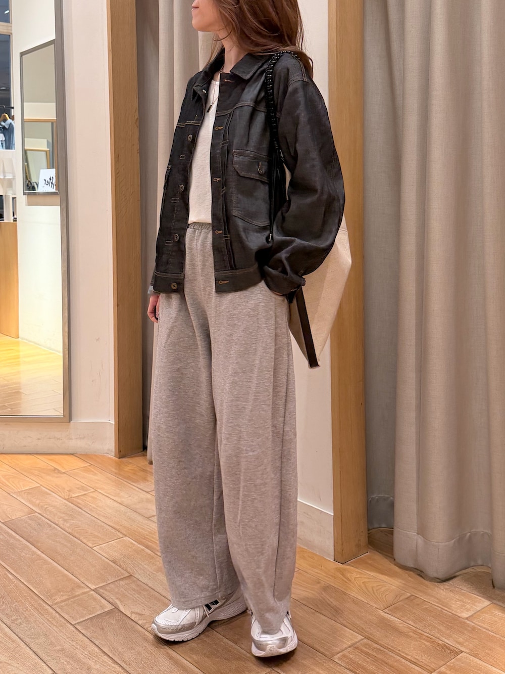 ブラック系のデニムジャケット、ブラック系のショルダーバッグを着用したレディースの春コーディネートの4枚目の写真