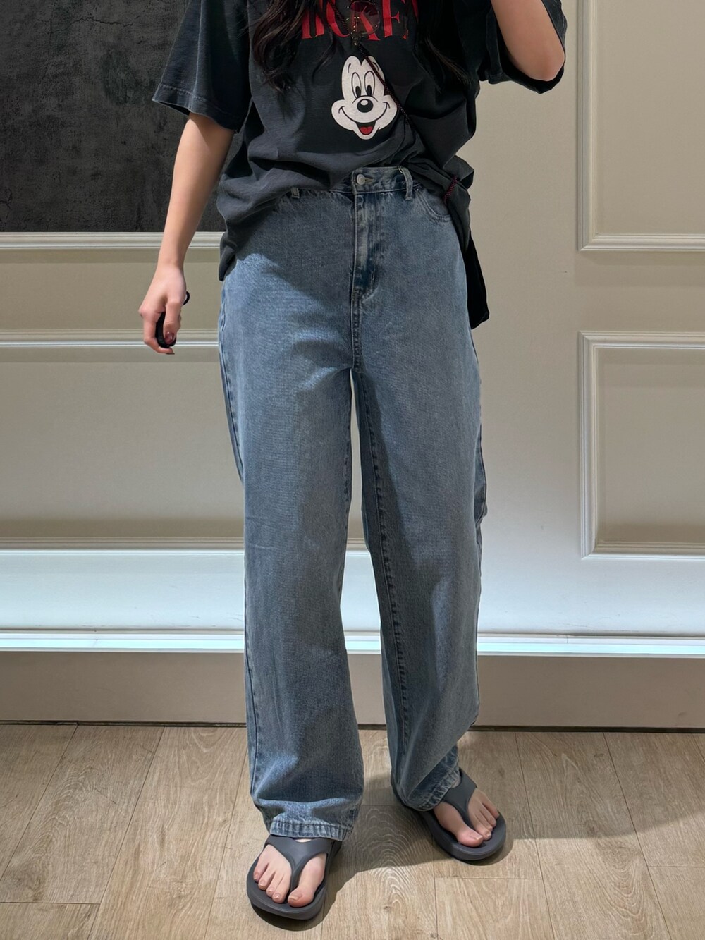 ブラック系のTシャツ/カットソー、ブラック系のデニムパンツ、グレー系のサンダルを着用したレディースの春コーディネートの5枚目の写真