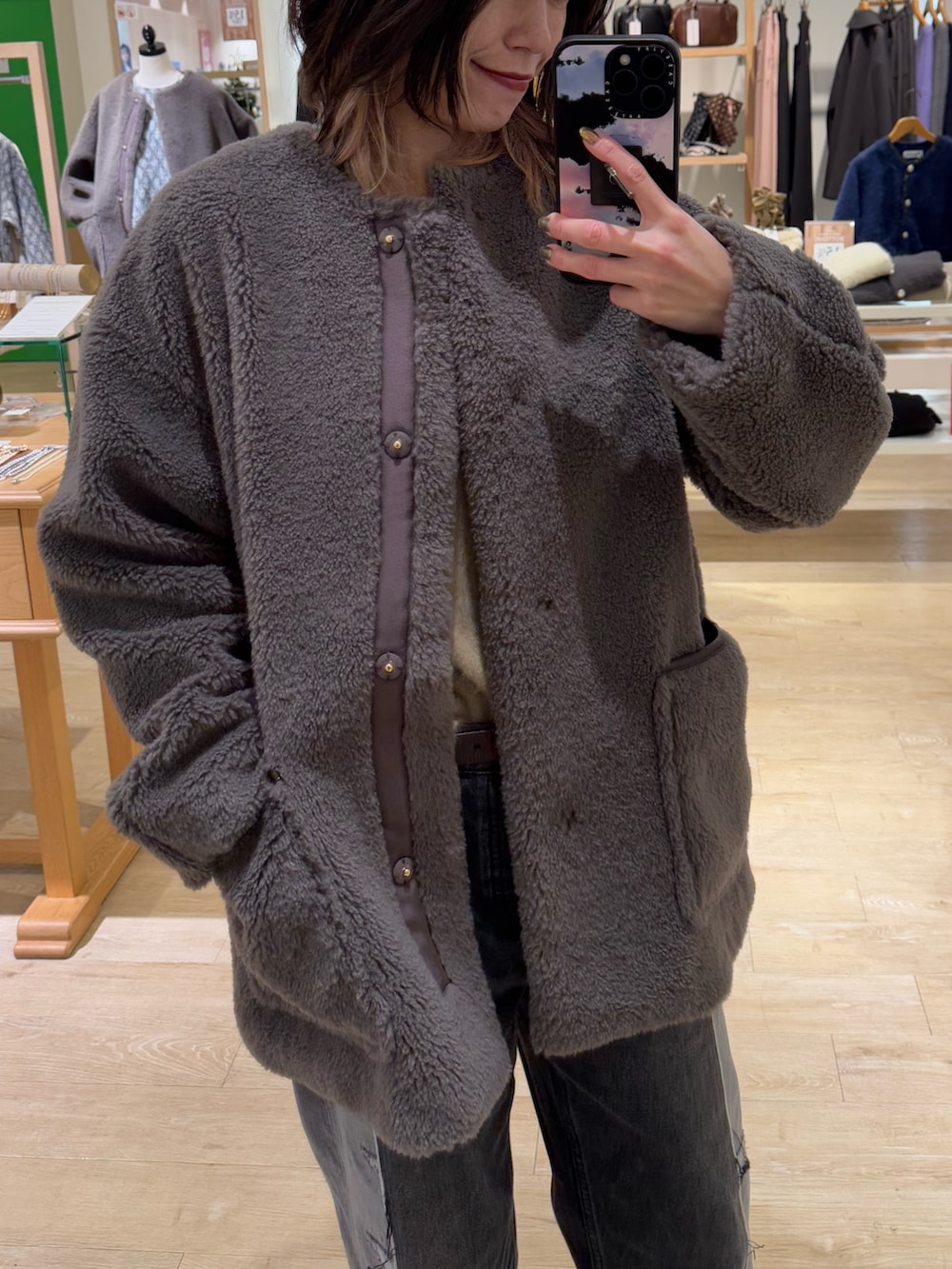 ブラウン系のノーカラーコート、ホワイト系のストール/ショールを着用したレディースの冬コーディネートの2枚目の写真