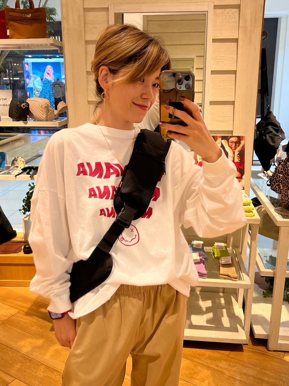 ホワイト系のTシャツ/カットソー、ブラック系のボディバッグ/ウエストポーチ、ベージュ系のその他パンツを着用したレディースの秋コーディネートの2枚目の写真