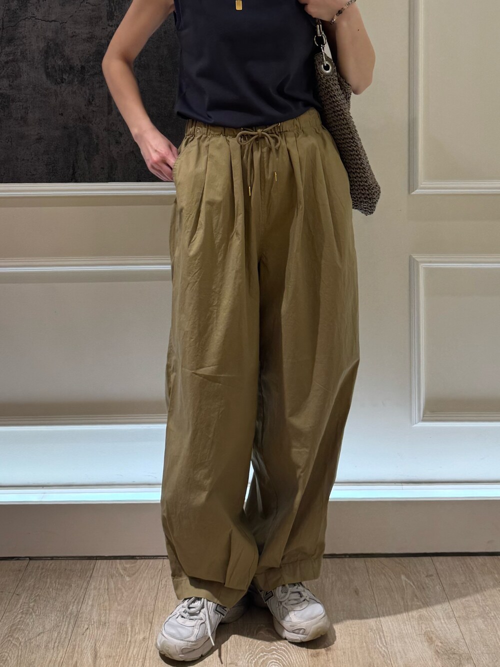 グレー系のタンクトップ、ベージュ系のその他パンツ、ホワイト系のキャップを着用したレディースの夏コーディネートの4枚目の写真