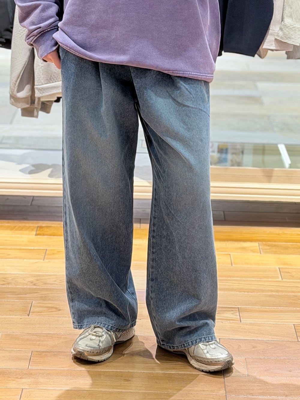 パープル系のスウェット、ブルー系のデニムパンツを着用したレディースの春コーディネートの3枚目の写真