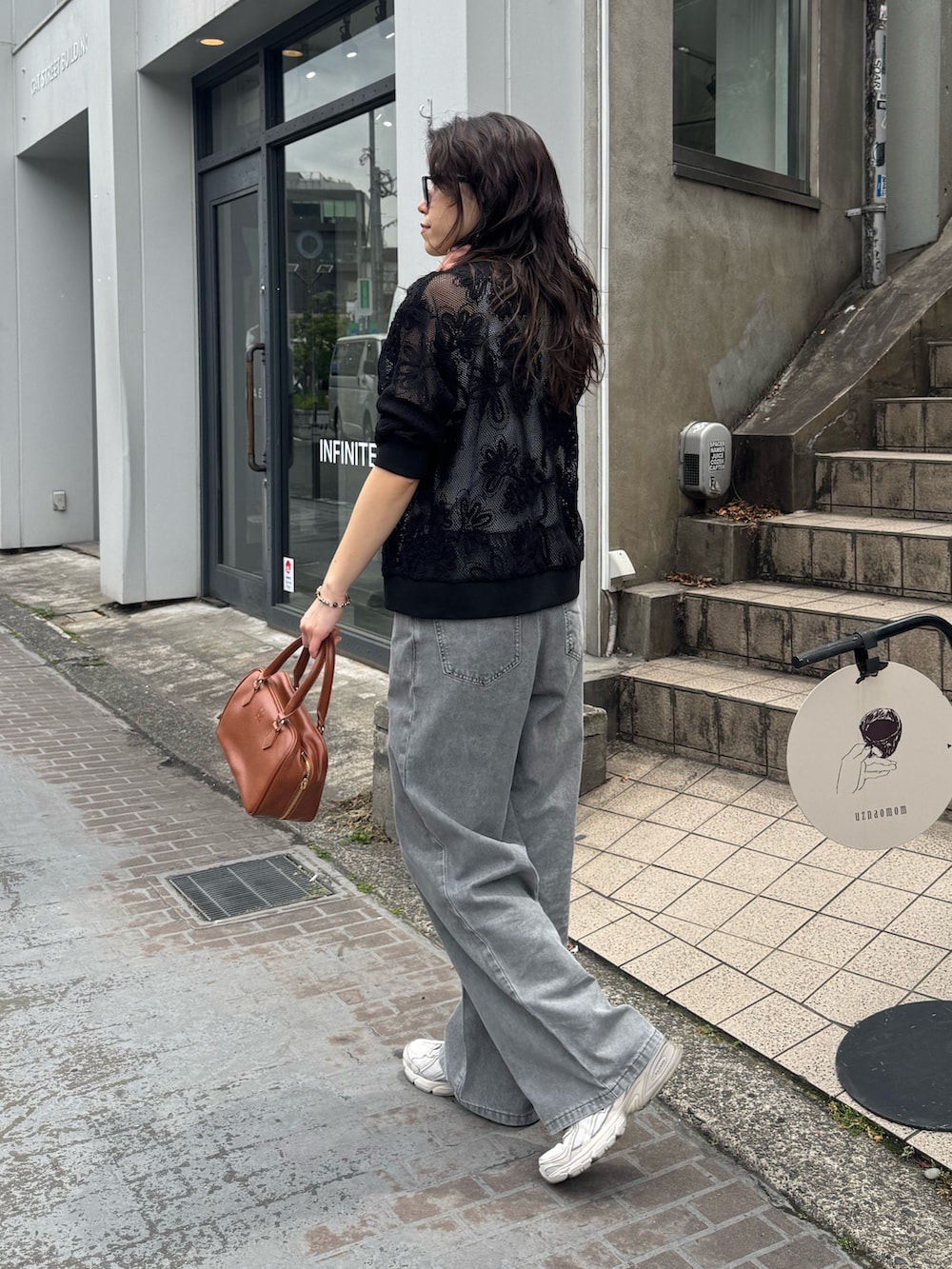 ブラック系のカーディガン/ボレロ、ベージュ系のデニムパンツを着用したレディースの春コーディネートの2枚目の写真