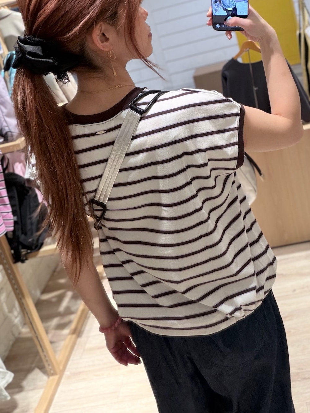 ホワイト系のTシャツ/カットソー、ブルー系のデニムパンツ、ブラック系のショルダーバッグを着用したレディースの夏コーディネートの4枚目の写真