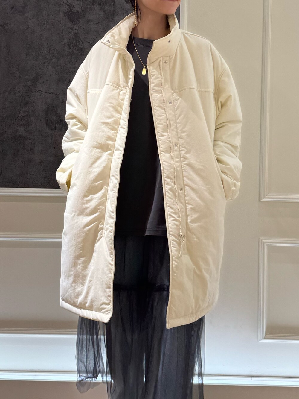 グリーン系のモッズコート、グレー系のスカート、ブルー系のデニムパンツを着用したレディースの冬コーディネートの3枚目の写真