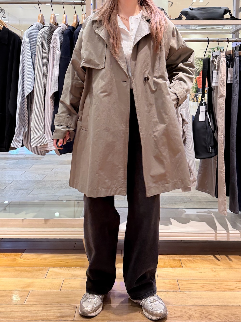 グリーン系のトレンチコート、ホワイト系のTシャツ/カットソー、ブルー系のデニムパンツを着用したレディースの春コーディネートの2枚目の写真