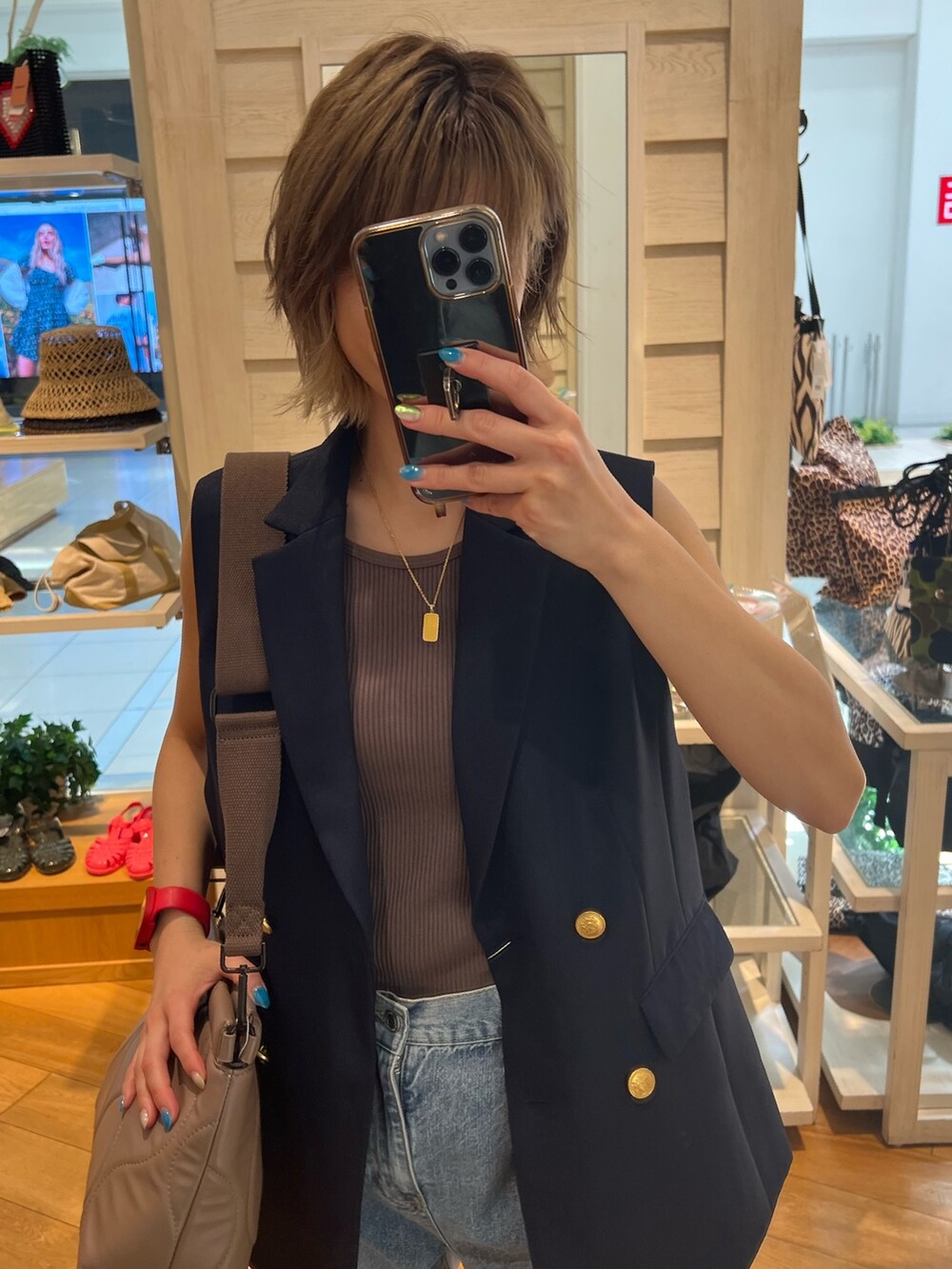 ブルー系のブルゾン、ブルー系のデニムパンツ、ブラック系のクラッチバッグを着用したレディースの夏コーディネートの2枚目の写真