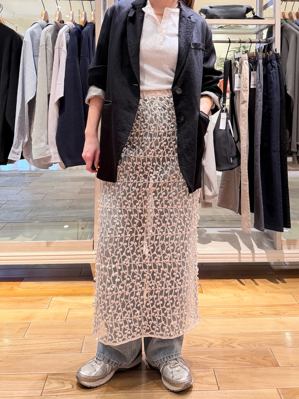 ホワイト系のTシャツ/カットソー、ブラック系のテーラードジャケット、ホワイト系のスカートを着用したレディースの春コーディネートの4枚目の写真