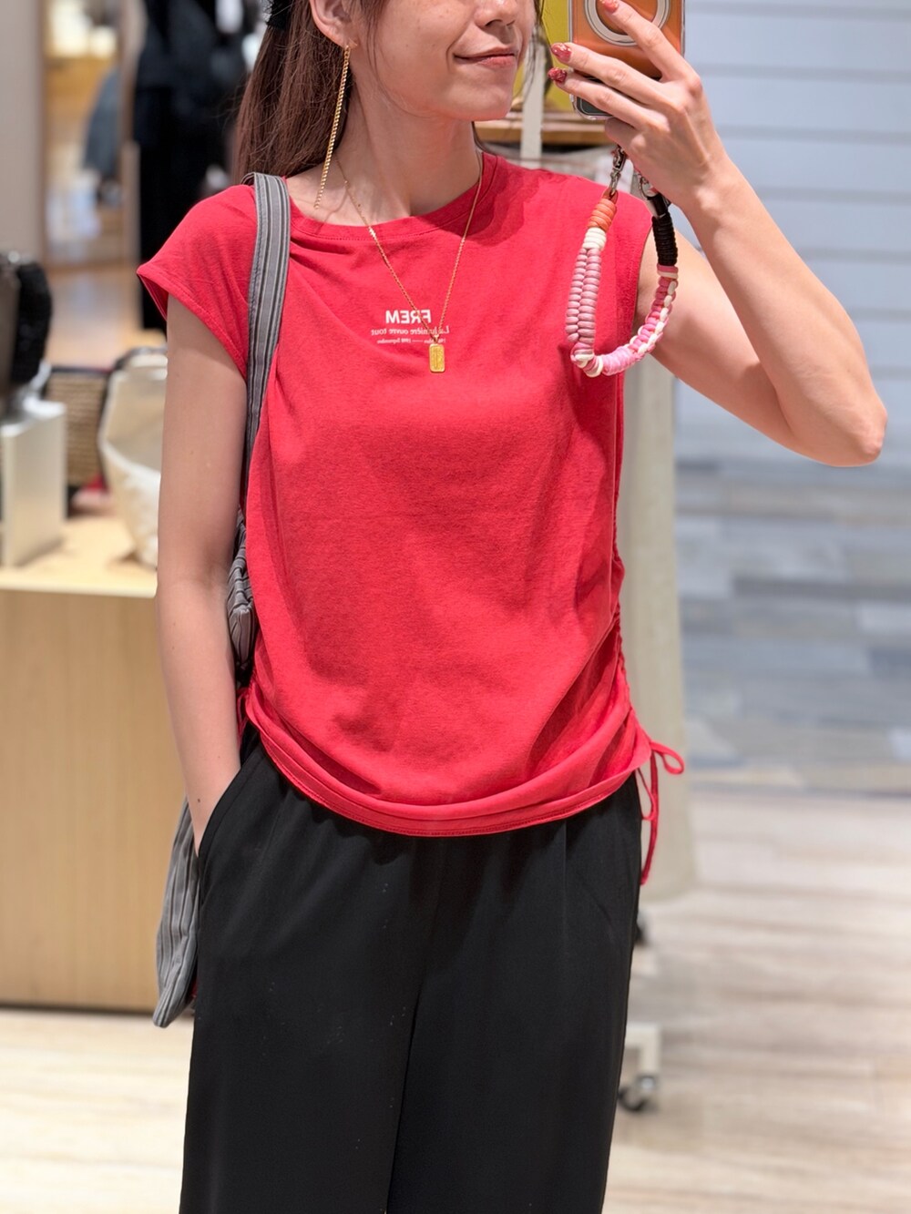レッド系のTシャツ/カットソー、ブラック系のその他パンツ、ブラック系のトートバッグを着用したレディースの夏コーディネートの2枚目の写真
