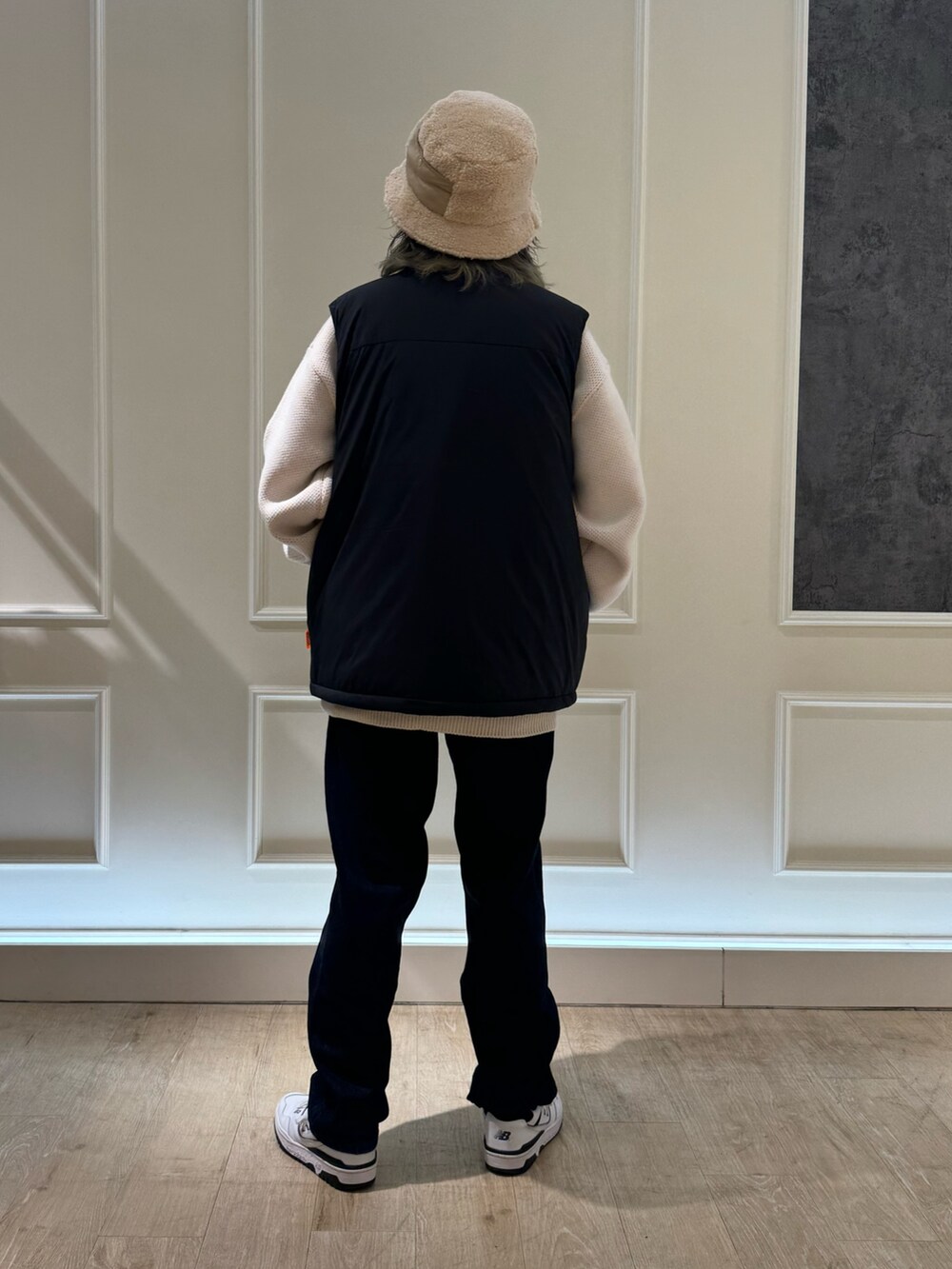 ブラック系のベスト、ホワイト系のニット/セーター、ベージュ系のハットを着用したレディースの秋コーディネートの4枚目の写真