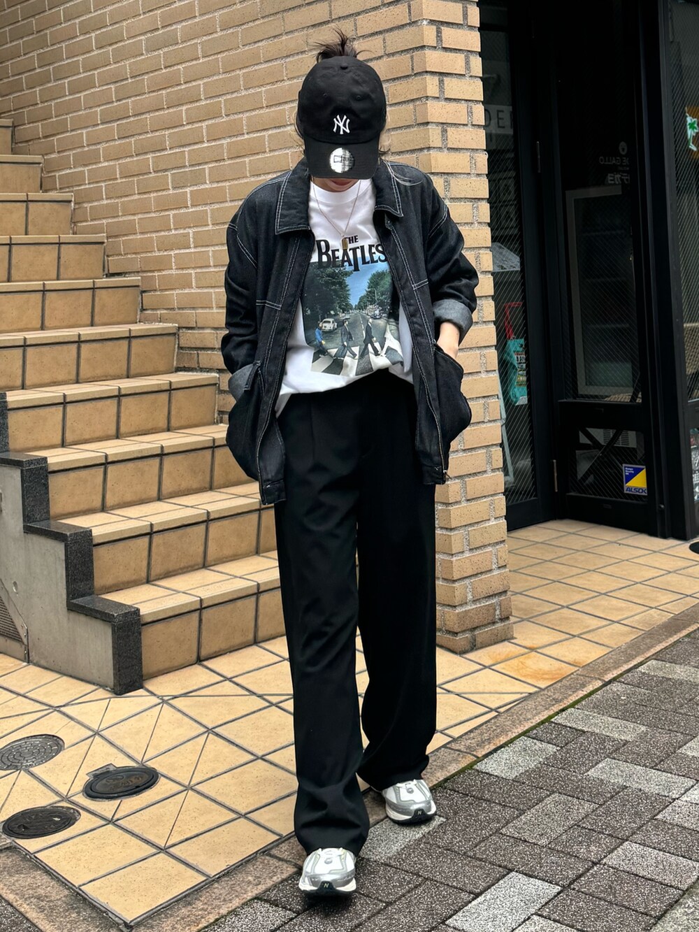 ブラック系のブルゾン、ホワイト系のTシャツ/カットソーを着用したレディースの秋コーディネートの2枚目の写真