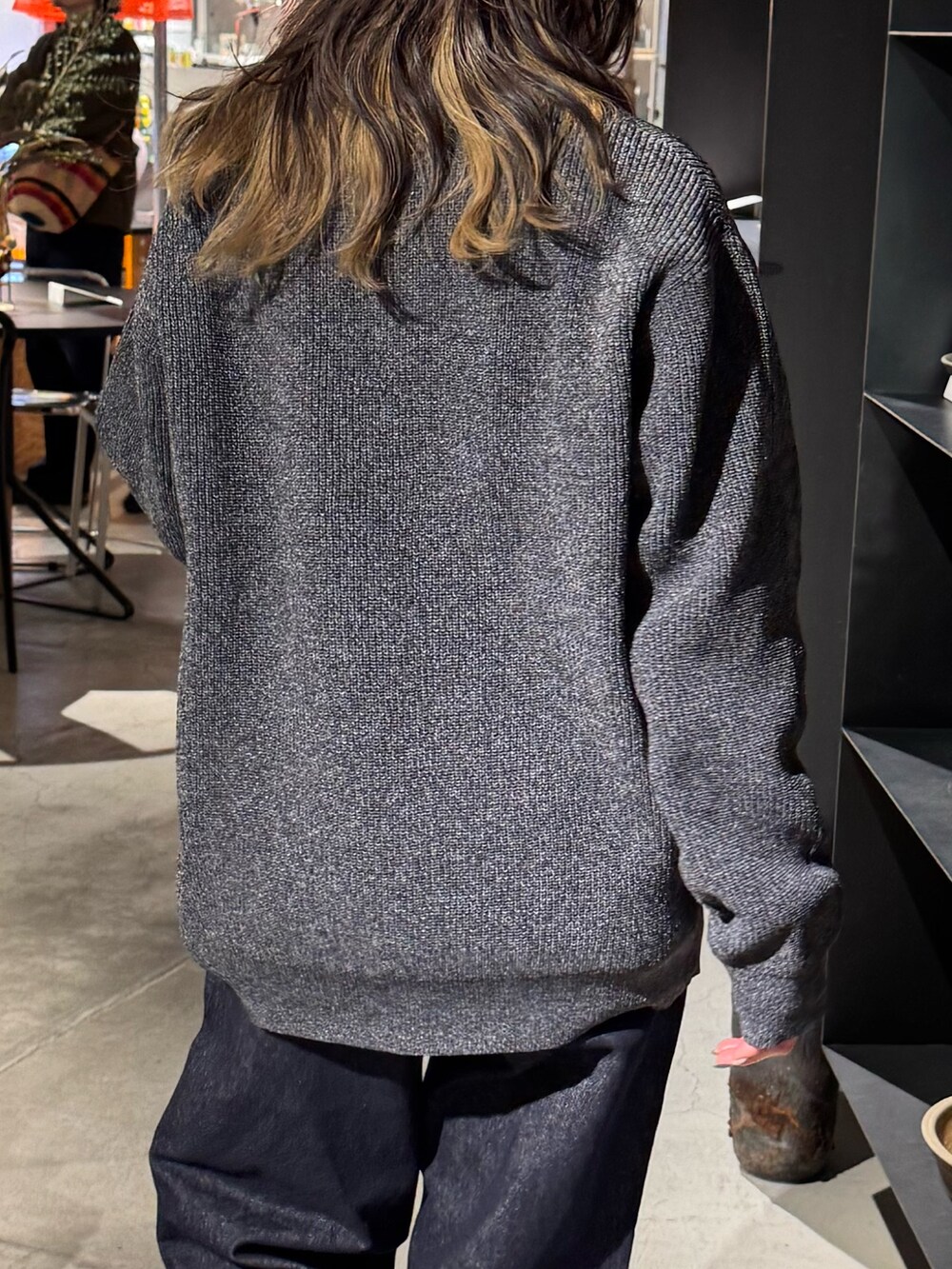グレー系のニット/セーター、ブルー系のデニムパンツを着用したレディースの冬コーディネートの4枚目の写真