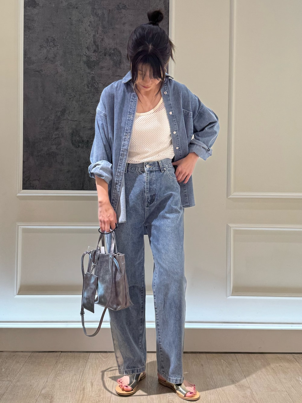 ブルー系のシャツ/ブラウス、シルバー系のショルダーバッグ、ブルー系のデニムパンツを着用したレディースの夏コーディネートの3枚目の写真