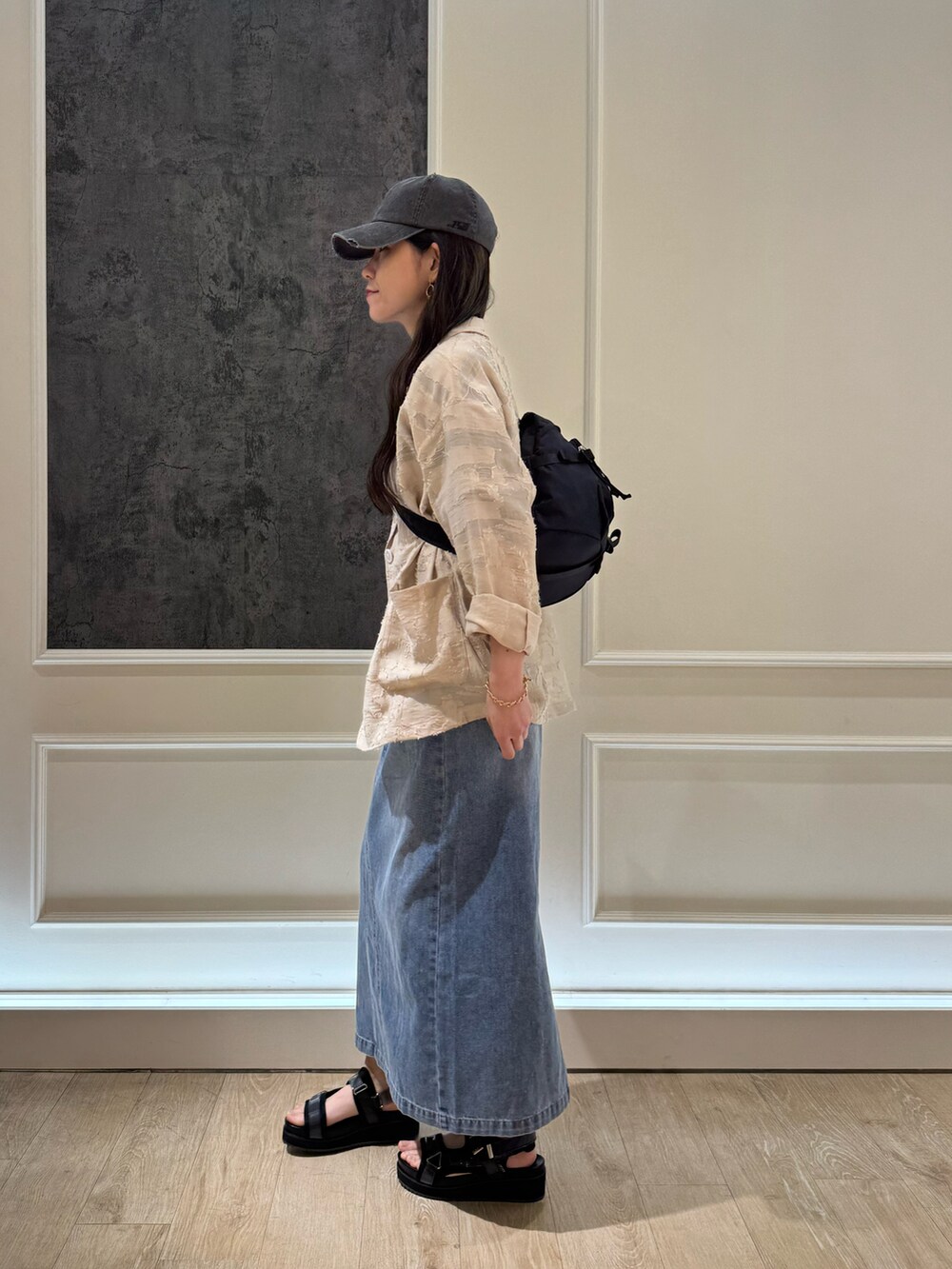 ブルー系のデニムスカート、ブラック系のテーラードジャケット、ブラック系のTシャツ/カットソーを着用したレディースの春コーディネートの2枚目の写真