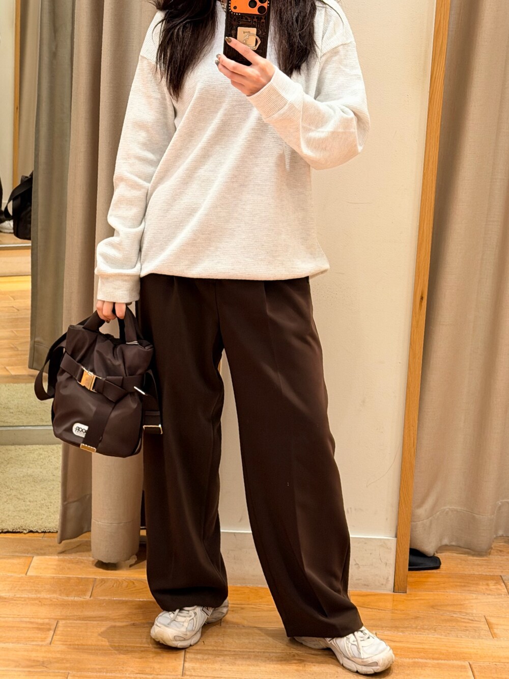 グレー系のTシャツ/カットソー、ブラウン系のショルダーバッグ、ブラウン系のスラックスを着用したレディースの秋コーディネートの2枚目の写真