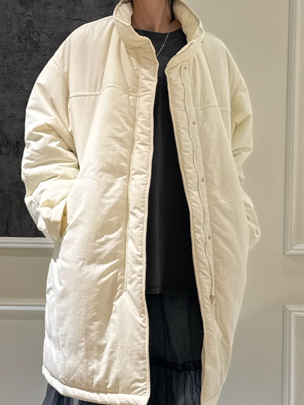 グリーン系のモッズコート、グレー系のTシャツ/カットソー、グレー系のスカートを着用したレディースの冬コーディネートの3枚目の写真