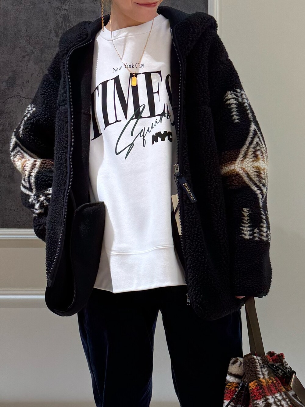 ホワイト系のブルゾン、ブラウン系のショルダーバッグ、ブラック系のその他パンツを着用したレディースの秋コーディネートの2枚目の写真