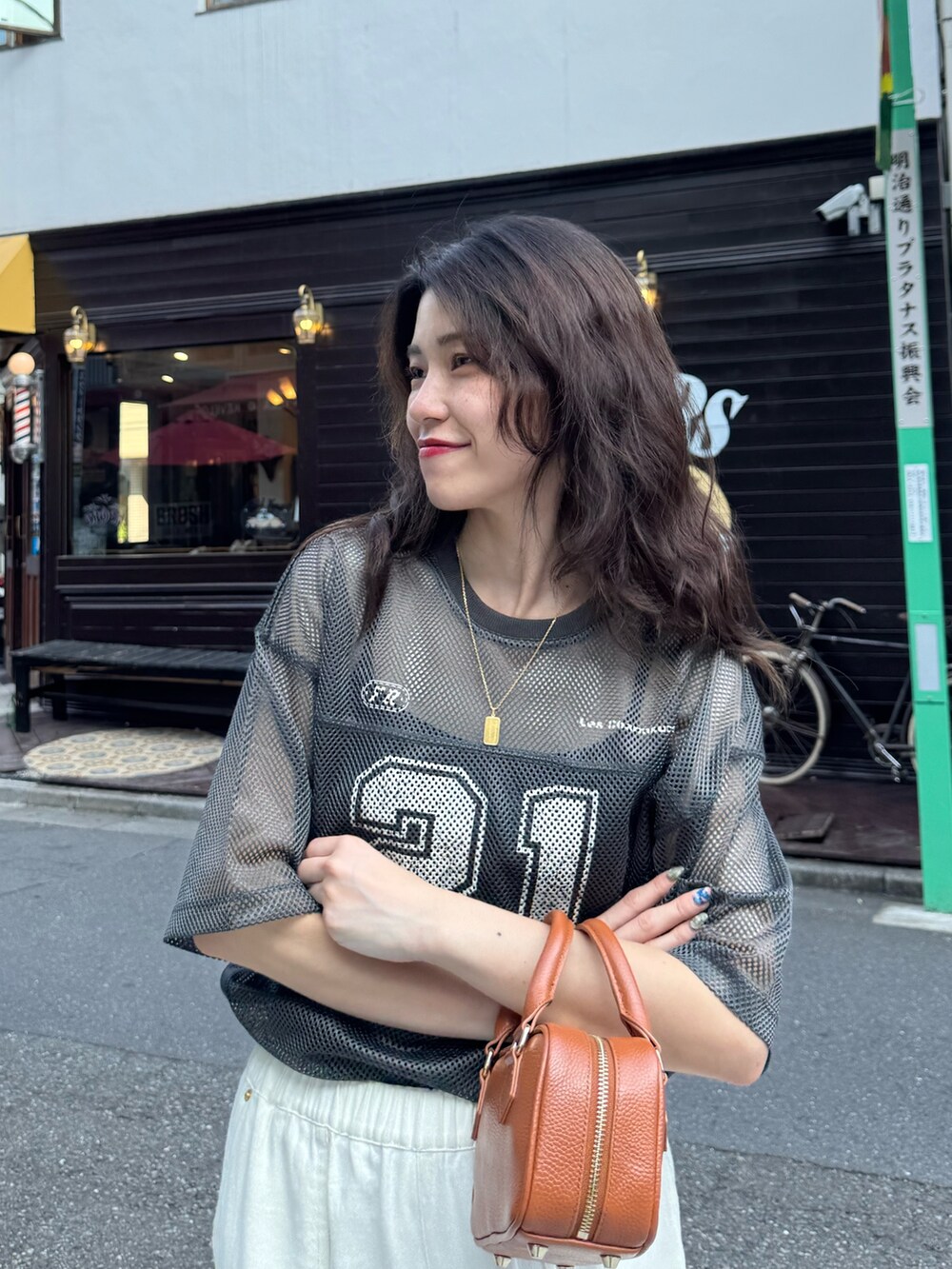グレー系のTシャツ/カットソー、ブルー系のデニムパンツ、イエロー系のショルダーバッグを着用したレディースの夏コーディネートの2枚目の写真