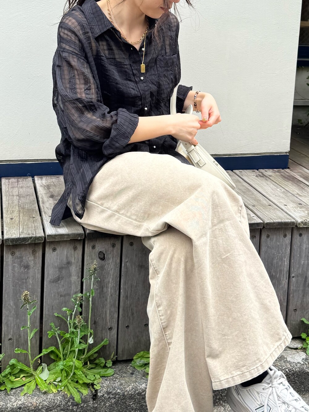 ブラック系のシャツ/ブラウス、ベージュ系のデニムパンツを着用したレディースの春コーディネートの2枚目の写真