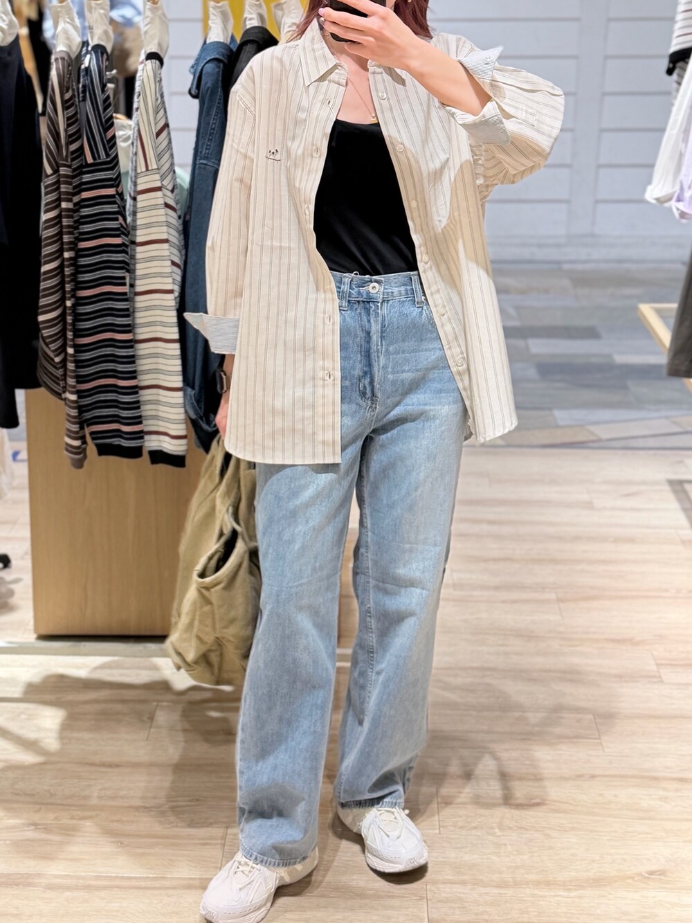 ホワイト系のシャツ/ブラウス、ブルー系のデニムパンツを着用したレディースの春コーディネートの2枚目の写真