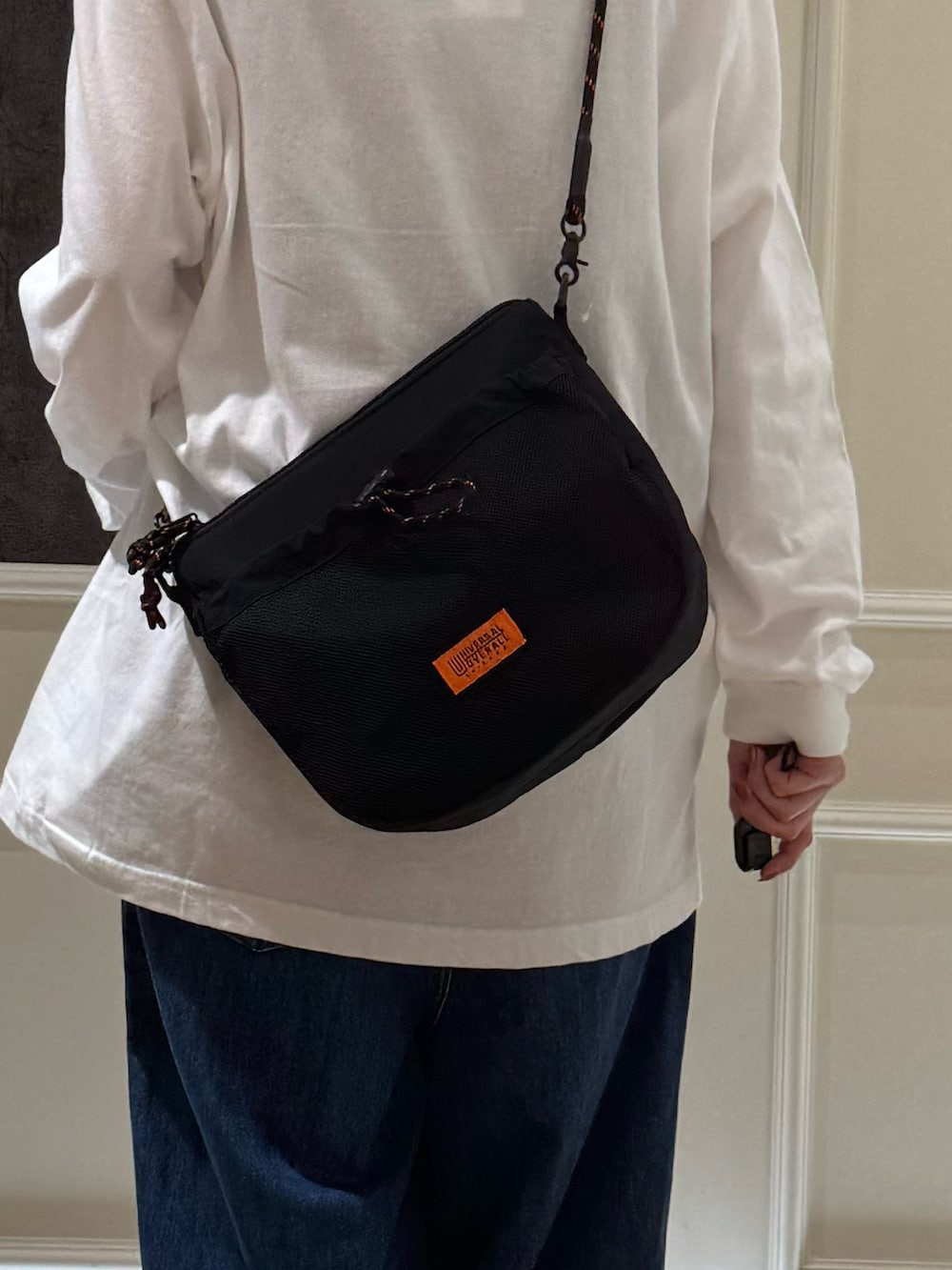 ホワイト系のTシャツ/カットソー、ブルー系のデニムパンツ、ブラック系のショルダーバッグを着用したレディースの秋コーディネートの5枚目の写真