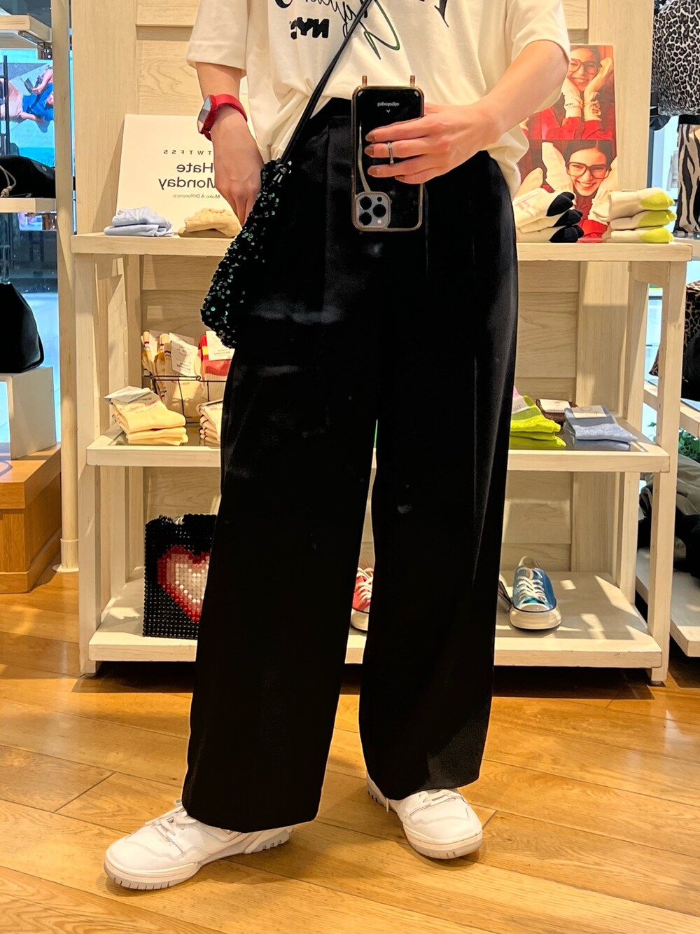 ブラック系のスラックス、グリーン系のショルダーバッグ、ホワイト系のTシャツ/カットソーを着用したレディースの夏コーディネートの3枚目の写真