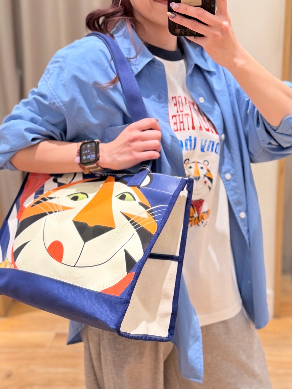 ブルー系のシャツ/ブラウス、ブルー系のトートバッグ、ホワイト系のTシャツ/カットソーを着用したレディースの春コーディネートの2枚目の写真