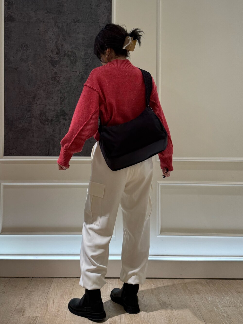 ピンク系のニット/セーター、ホワイト系のカーゴパンツ、ブラック系のブーツを着用したレディースの冬コーディネートの3枚目の写真