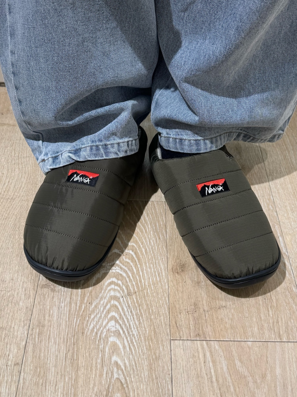 ブラック系のスウェット、ブラック系のダウンジャケット/コート、グリーン系のサンダルを着用したレディースの秋コーディネートの3枚目の写真