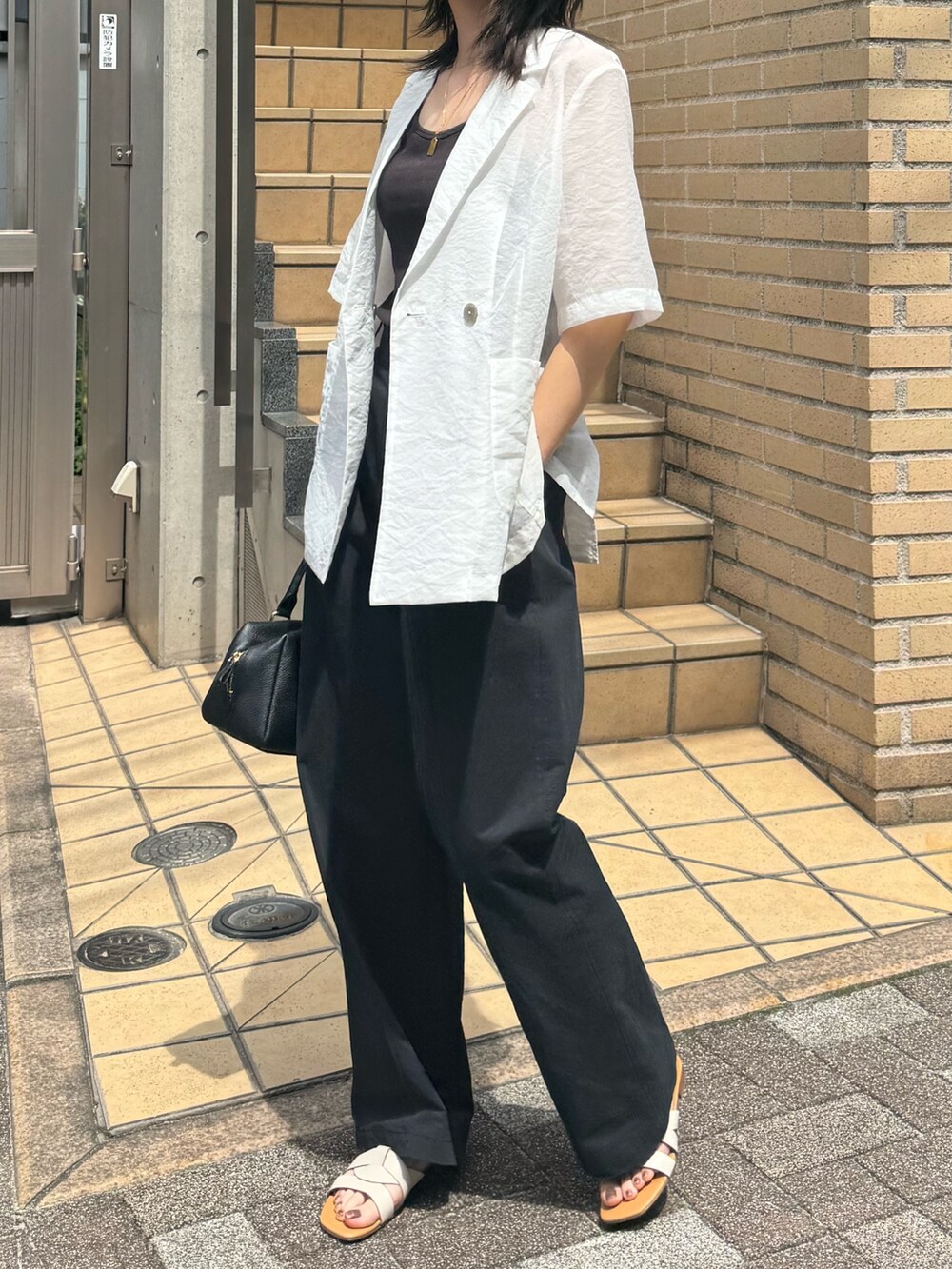 ホワイト系のダウンジャケット/コート、ブラック系のチノパンツを着用したレディースの夏コーディネートの2枚目の写真