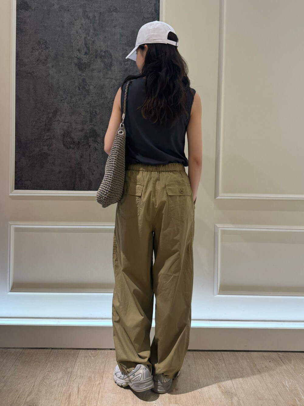 グレー系のタンクトップ、ベージュ系のその他パンツ、ホワイト系のキャップを着用したレディースの夏コーディネートの6枚目の写真