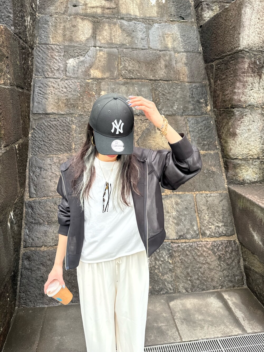 ホワイト系のTシャツ/カットソー、ホワイト系のその他パンツ、ブラック系のブルゾンを着用したレディースの春コーディネートの3枚目の写真