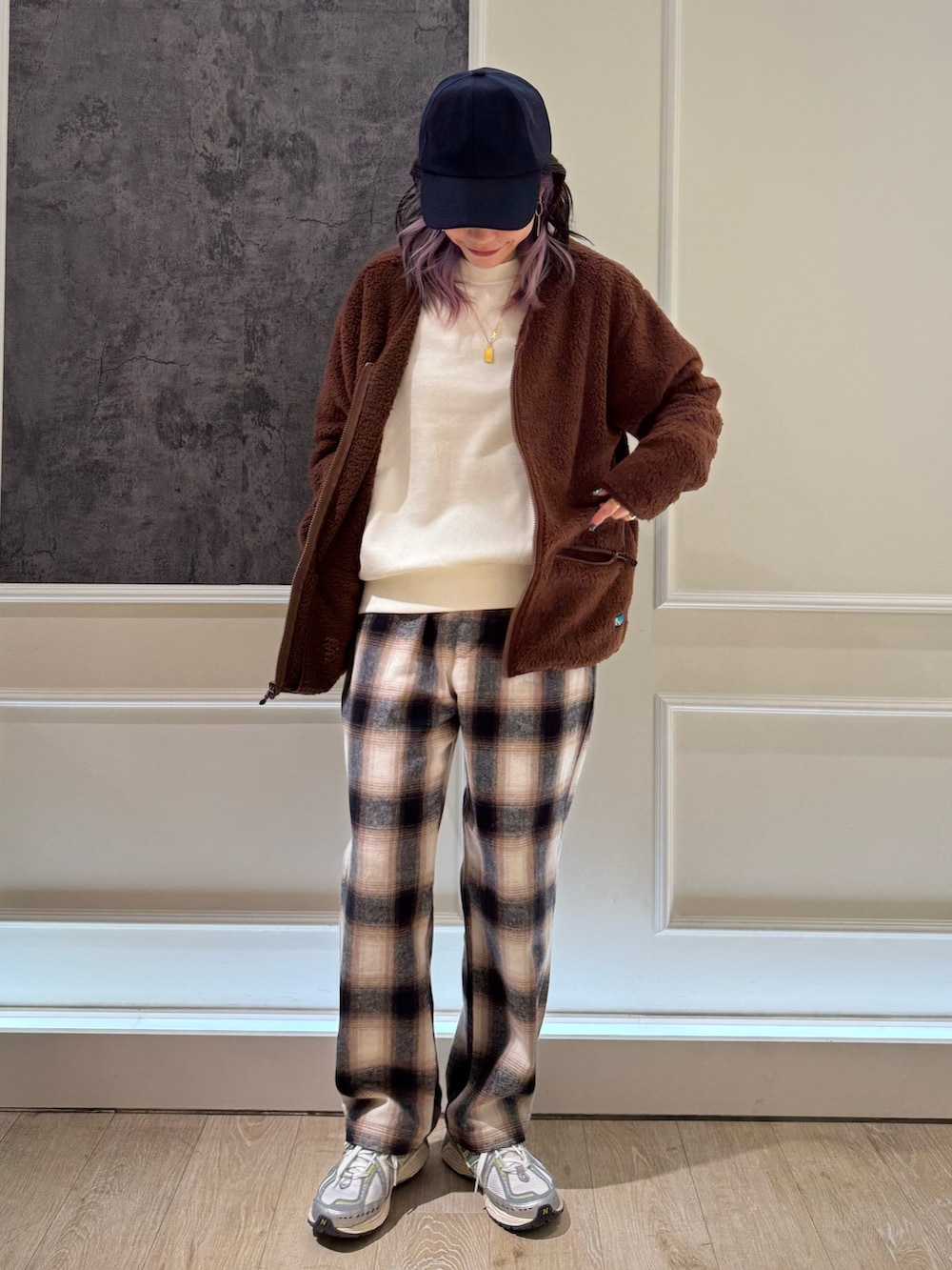 ブラウン系のカーディガン/ボレロ、ブルー系のキャップを着用したレディースの秋コーディネートの2枚目の写真