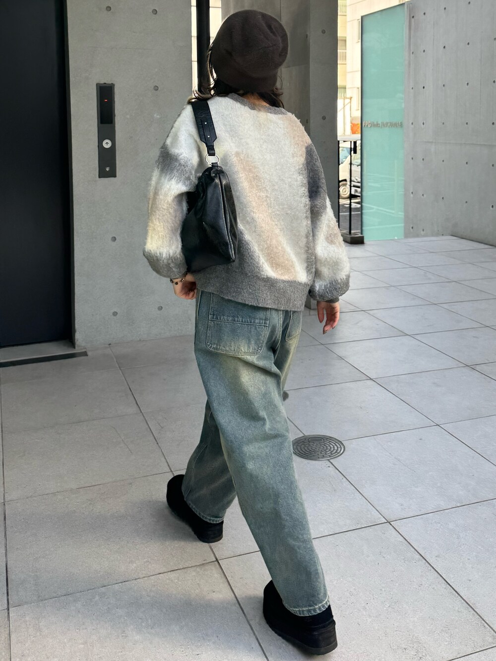 グレー系のニット/セーター、ブルー系のデニムパンツ、ブラック系のショルダーバッグを着用したレディースの冬コーディネートの5枚目の写真